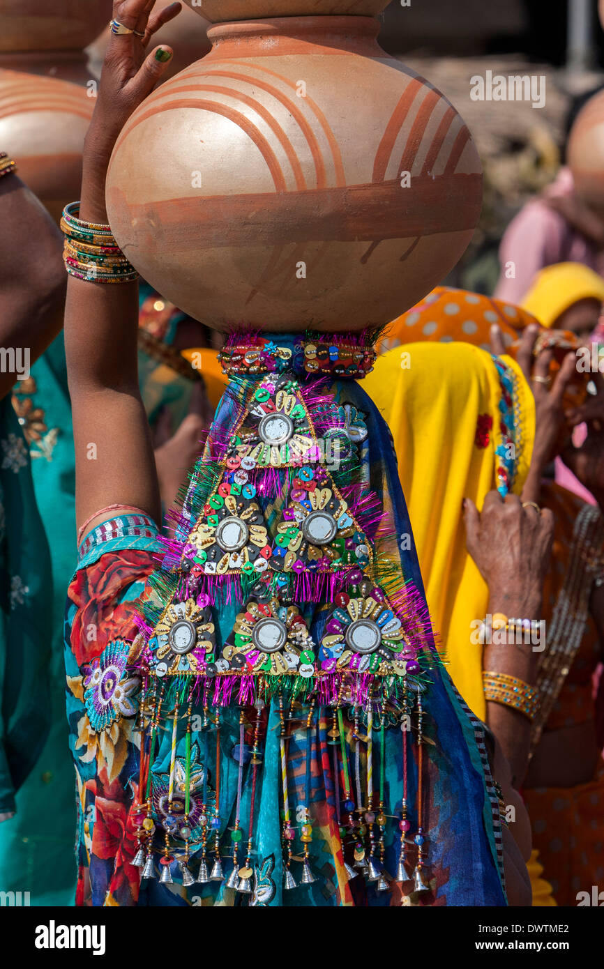 Abhaneri, Rajasthan, Indien. Bunten Pailletten Kopfschmuck einer Frau zu Fuß zum Haus eine Braut vor der Hochzeit Feier. Stockfoto