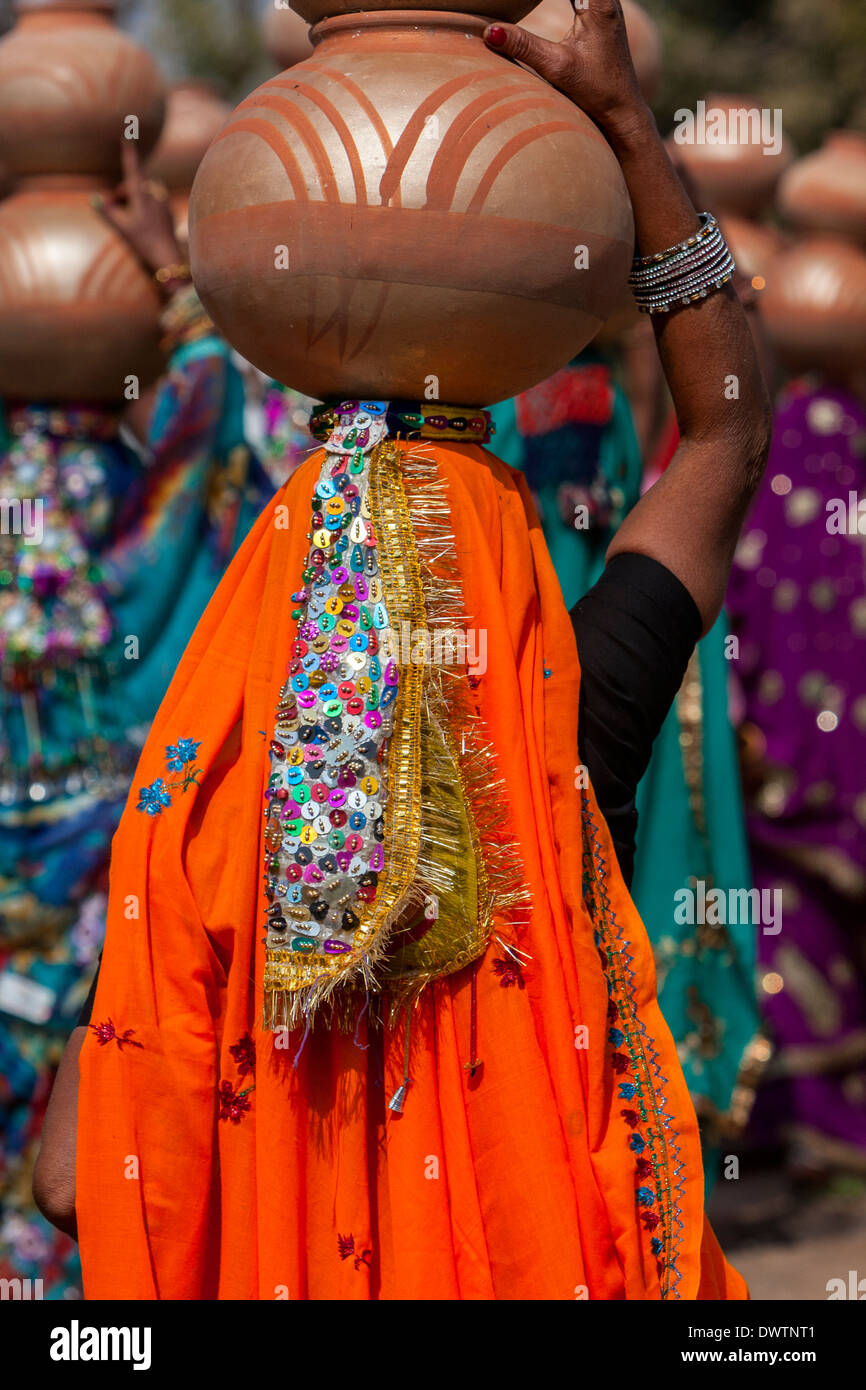 Abhaneri, Rajasthan, Indien. Bunten Pailletten Kopfschmuck einer Frau zu Fuß zum Haus eine Braut vor der Hochzeit Feier. Stockfoto