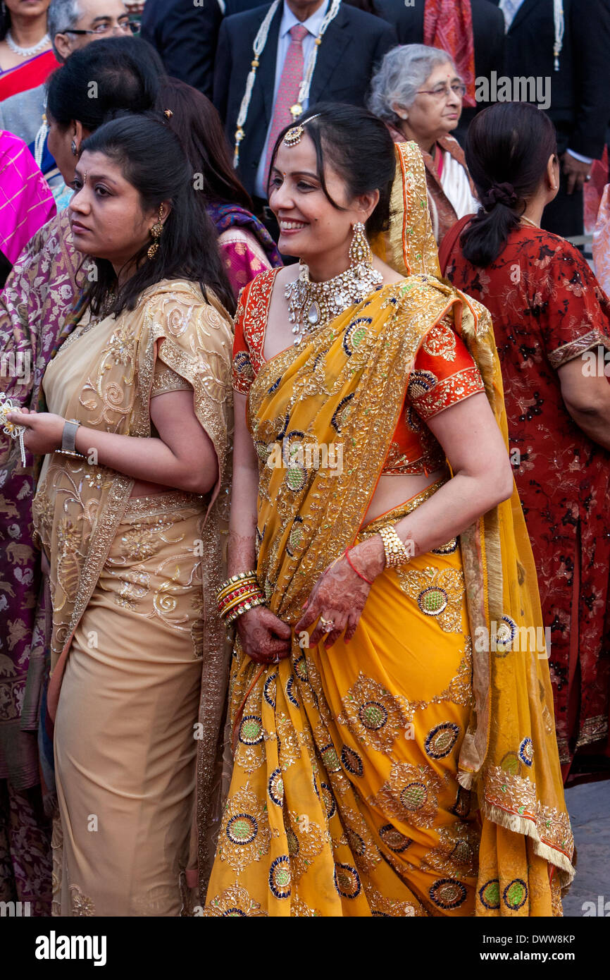Jaipur, Rajasthan, Indien. Indische Frauen in Saris und Schmuck bei einer Hochzeitsfeier ankommen. Beachten Sie Henna Dekoration auf Händen. Stockfoto