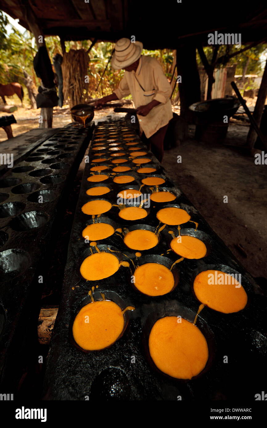 Moises Ibarra gießt gekochten Zuckerrohrsaft in Formen bei der Herstellung von Raspadura, Provinz Cocle, Republik Panama, Mittelamerika. Stockfoto