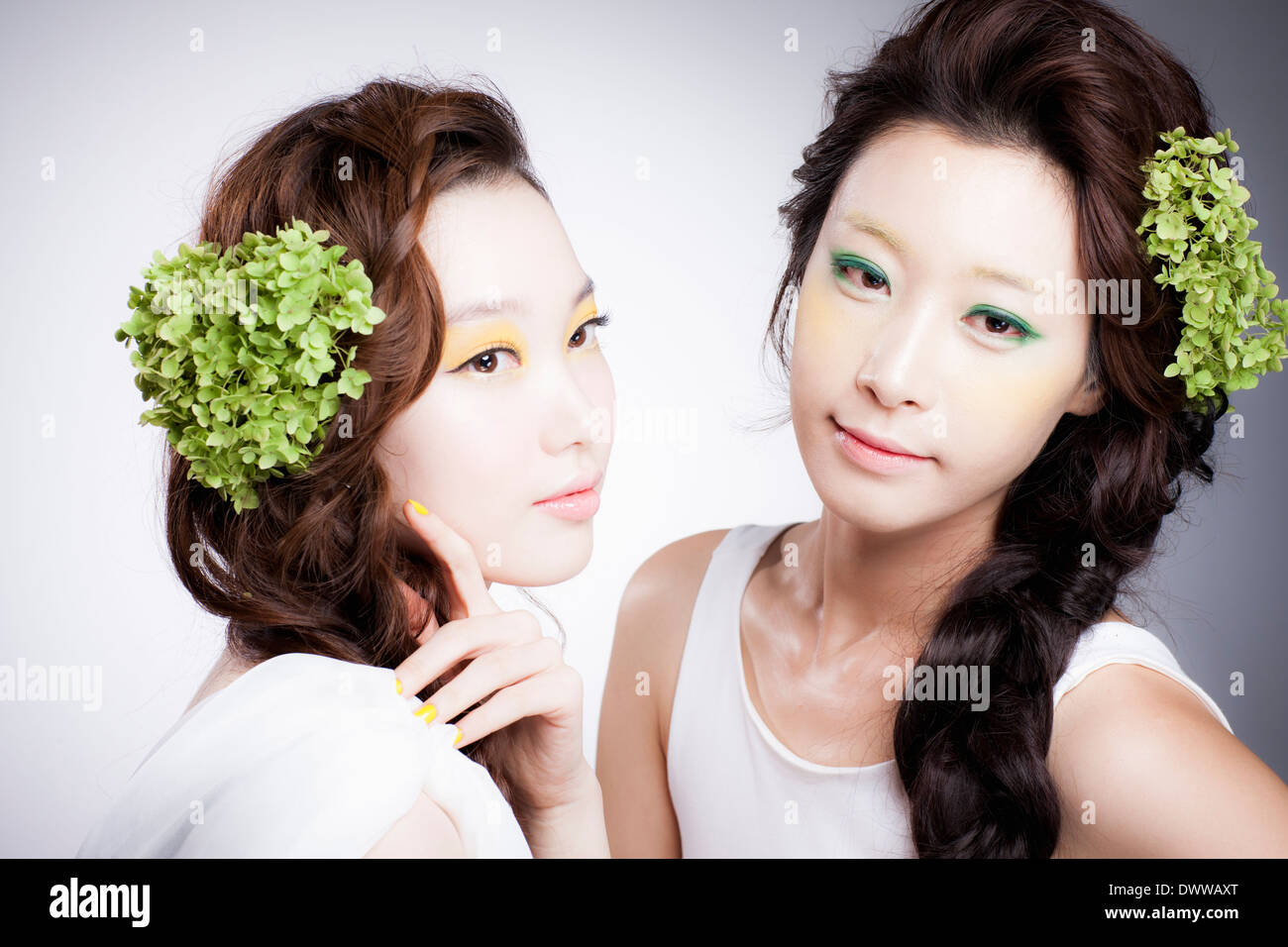 zwei Frauen mit schweren Make-up und eine grüne Dekoration in den Haaren Stockfoto