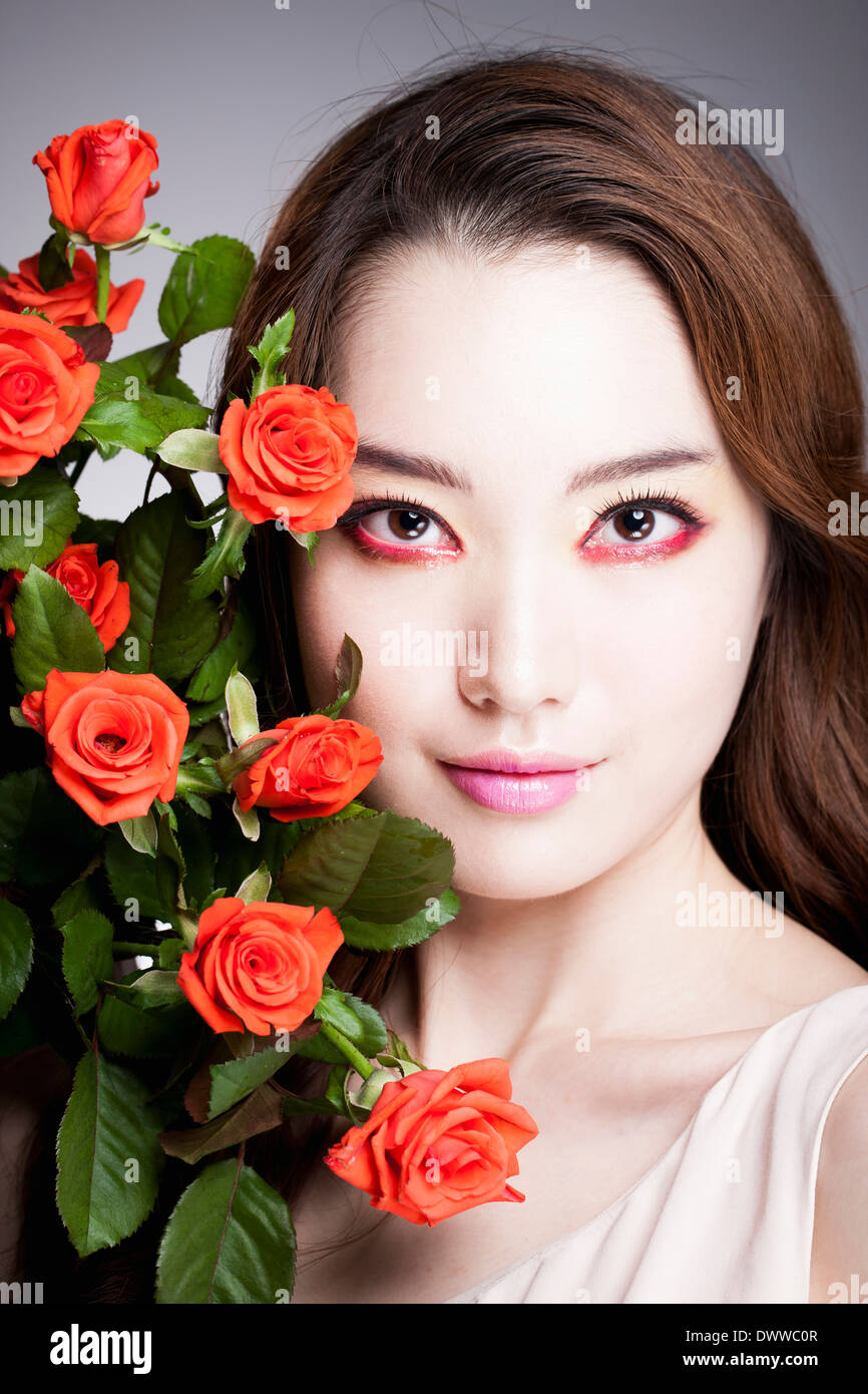 eine Frau mit schweren roten Make-up und Rosen Stockfoto