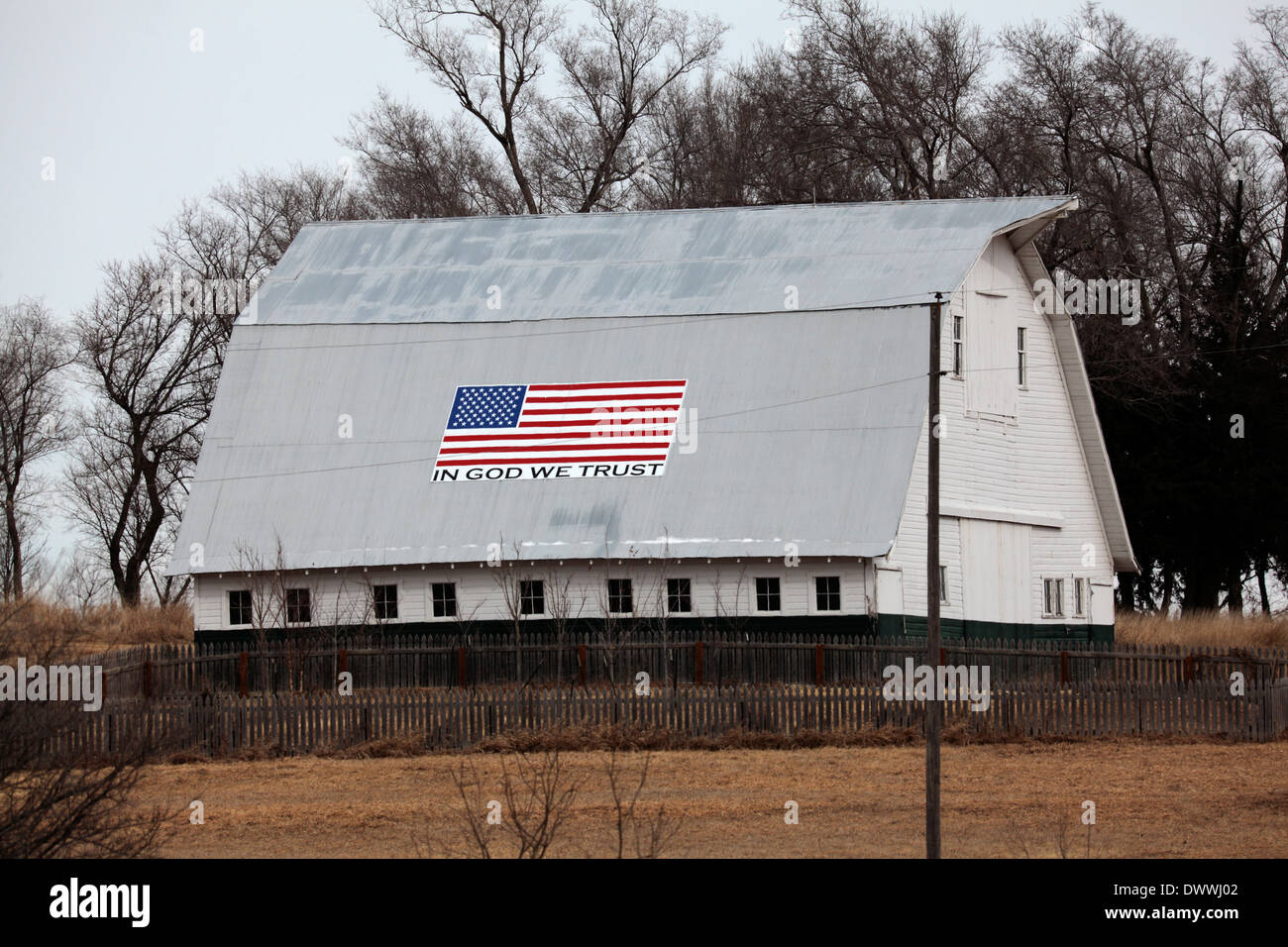 Scheune mit "In God We Trust" und amerikanische Flagge auf dem Dach. Stockfoto