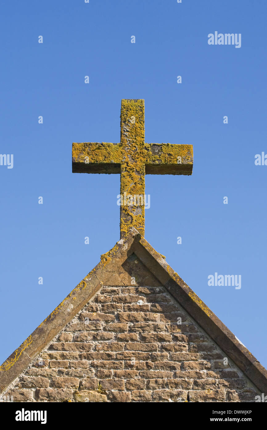 Flechten bedeckt Kreuz vor einem blauen Himmel. Stockfoto