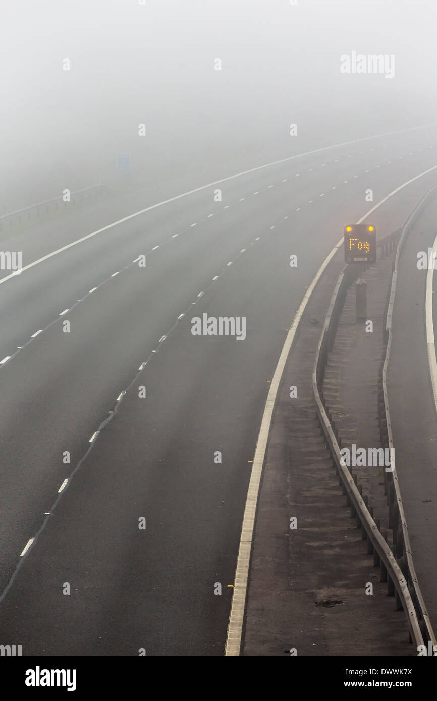 UK-Autobahn mit Nebel Warnschild in Nebel oder Nebel Stockfoto