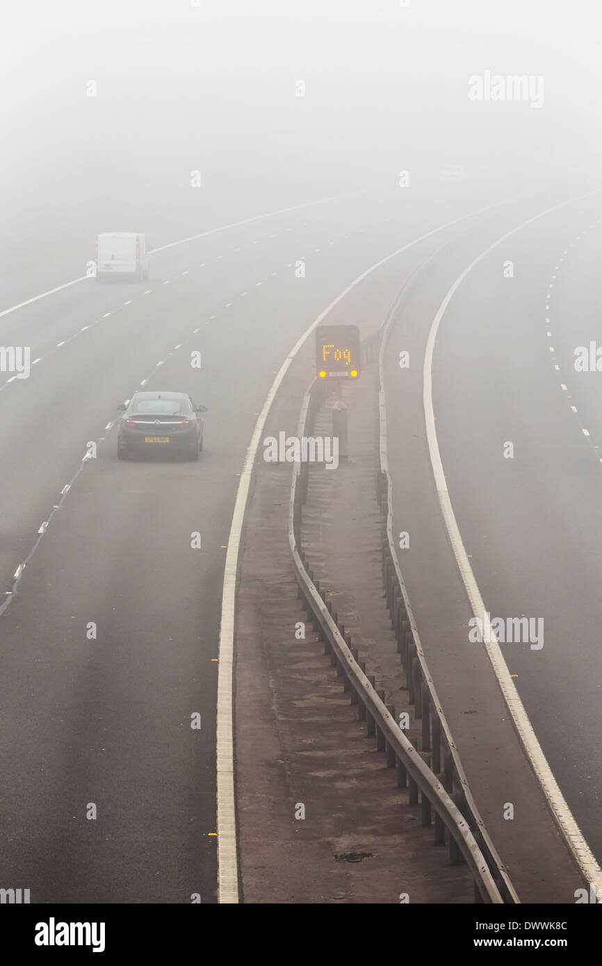 UK-Autobahn mit Nebel Warnschild in Nebel oder Nebel Stockfoto