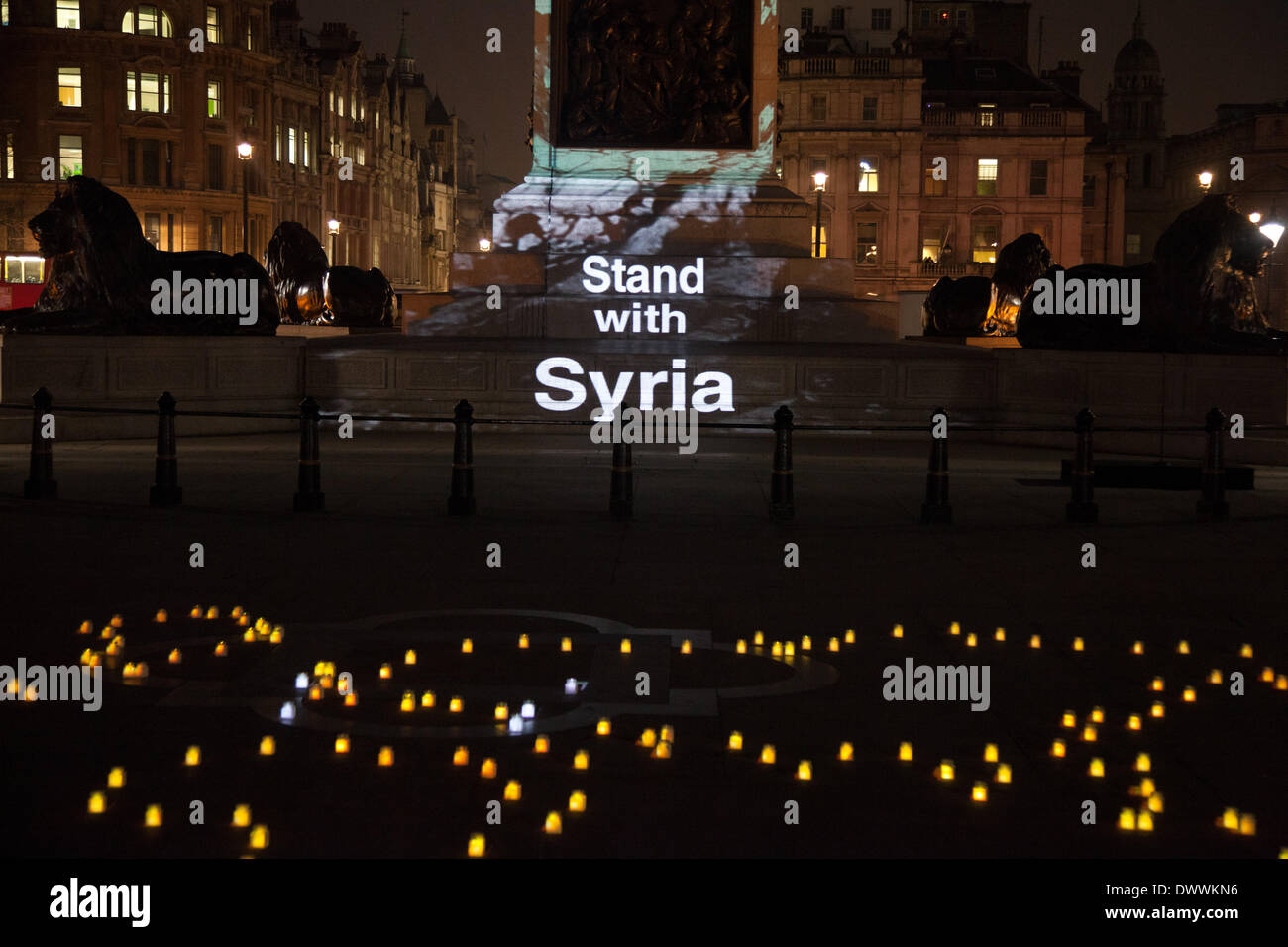 London, UK. 13. März 2014. Nelson Säule auf dem Trafalgar Square in London mit Kunstwerken von Banksy als Bestandteil einer Mahnwache, leuchtet um die Ständer mit Syrien-Kampagne zu starten. Die Kampagne soll unterstreichen, die der Krieg in Syrien geht schon seit drei Jahren am 15. März und die den Krieg beenden muss. Bildnachweis: Kristian Buus/Alamy Live-Nachrichten Stockfoto