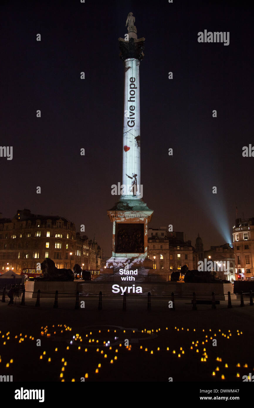 London, UK. 13. März 2014. Nelson Säule auf dem Trafalgar Square in London mit Kunstwerken von Banksy als Bestandteil einer Mahnwache, leuchtet um die Ständer mit Syrien-Kampagne zu starten. Die Kampagne soll unterstreichen, die der Krieg in Syrien geht schon seit drei Jahren am 15. März und die den Krieg beenden muss. Bildnachweis: Kristian Buus/Alamy Live-Nachrichten Stockfoto