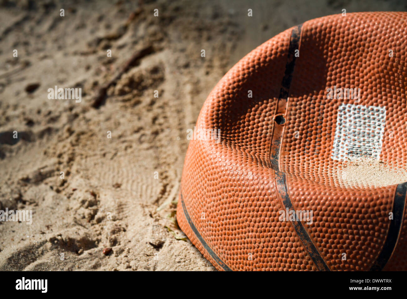 Flache alte Basketball liegen in einer sandbox Stockfoto