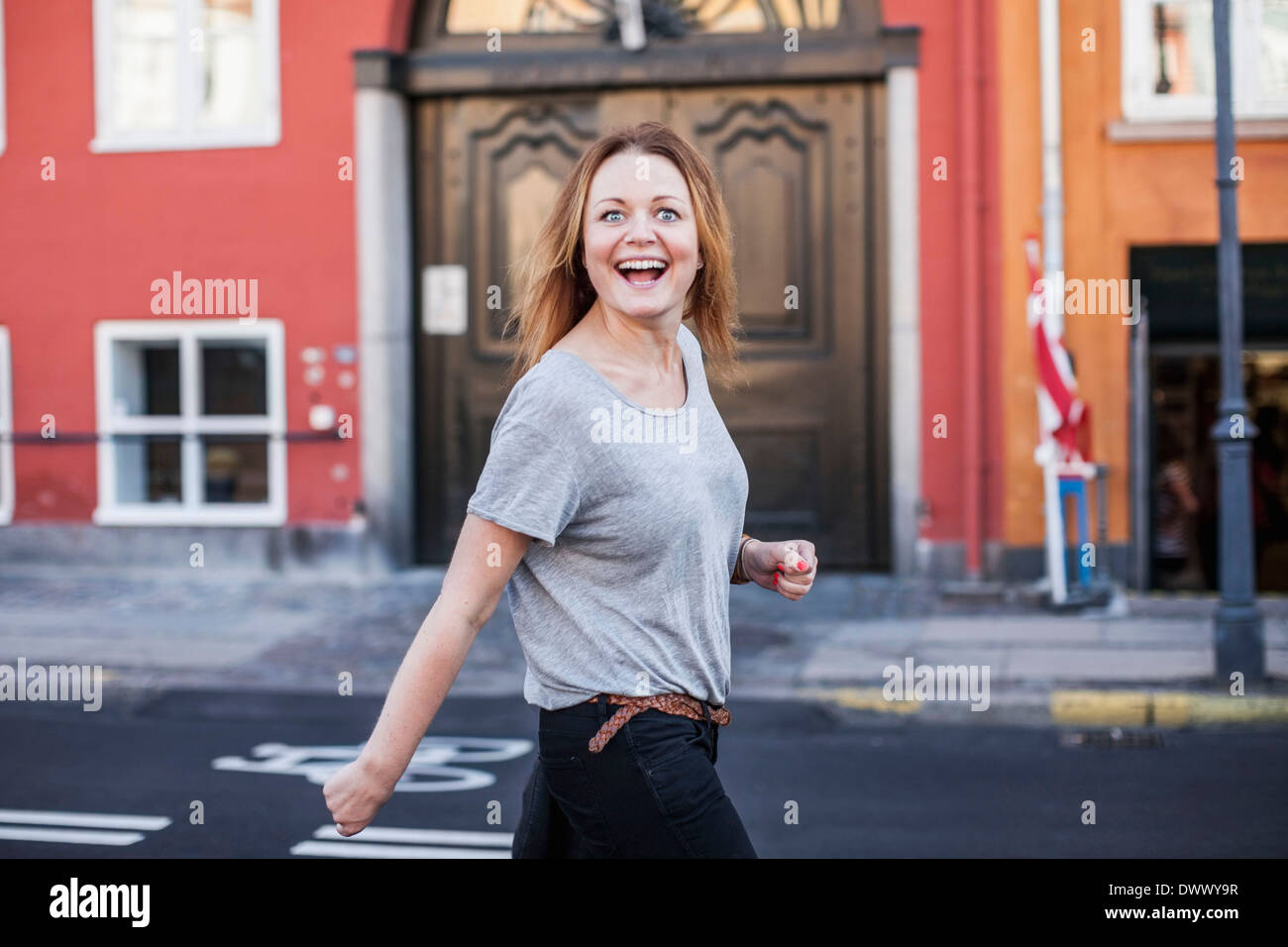 Porträt von glücklich Mitte erwachsenen Frau zu Fuß auf Stadtstraße Stockfoto