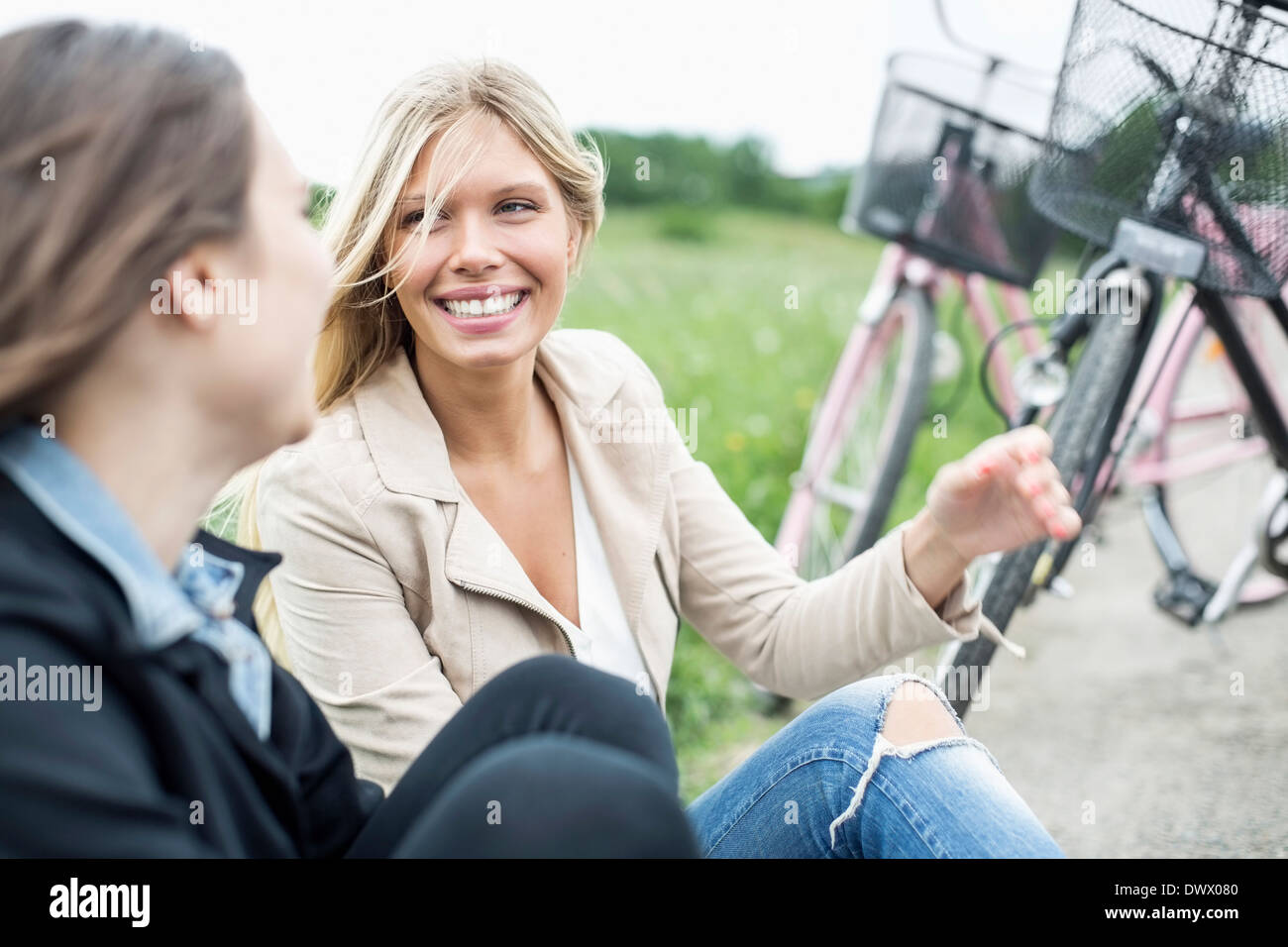 Glückliche junge Frau im Gespräch mit Freundin auf Landstraße Stockfoto