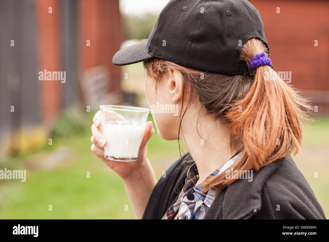 Seitenansicht der Frau trinkt Milch am Bauernhof Stockfoto