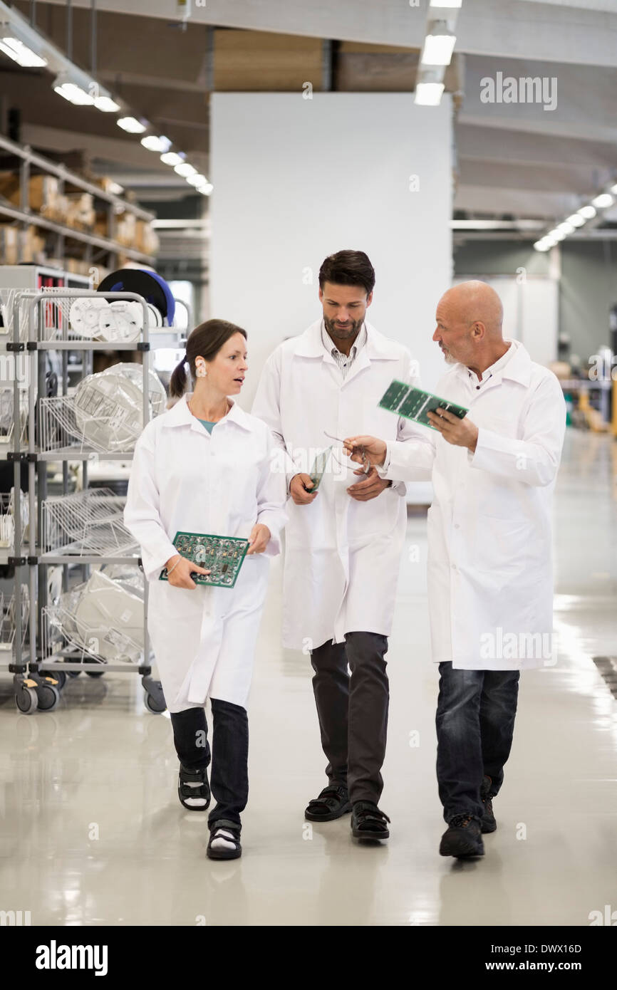 Voller Länge Ingenieure diskutieren Leiterplatten in Fabrik Stockfoto