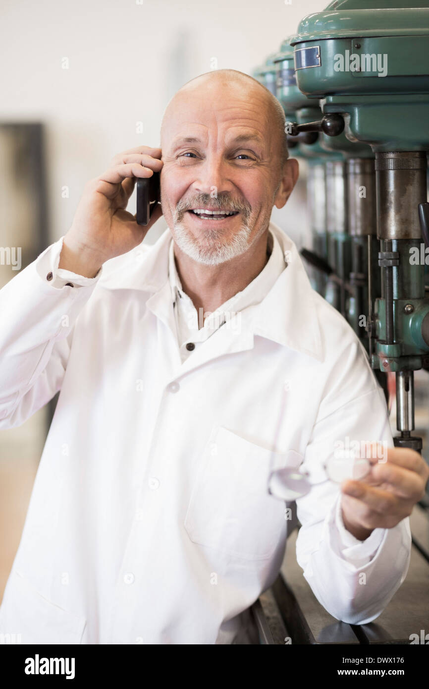 Porträt des Lächelns Ingenieur Beantwortung Handy in Fabrik Stockfoto