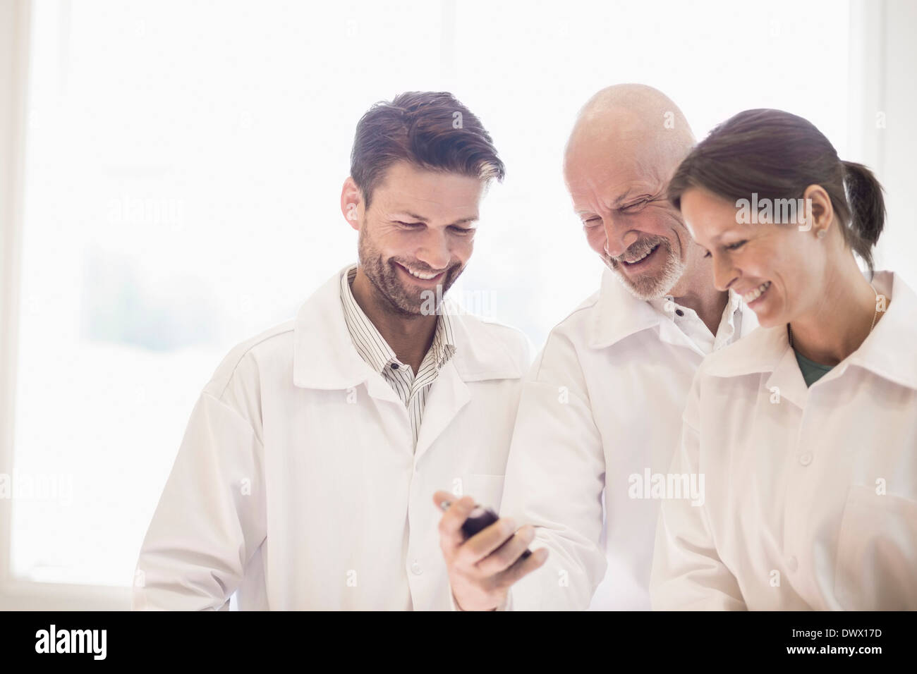 Glücklich Ingenieure mit Handy in der verarbeitenden Industrie Stockfoto