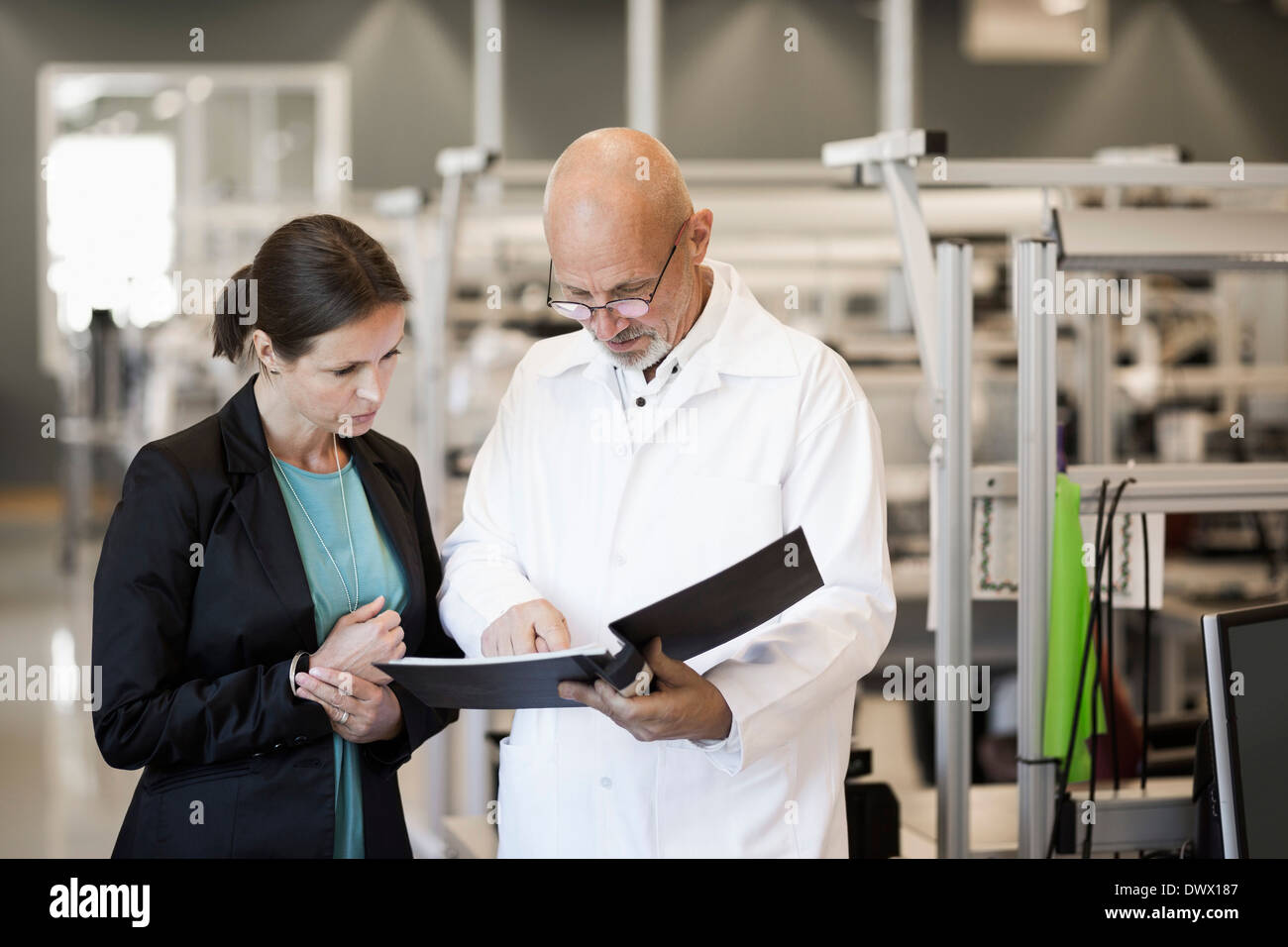 Männliche Ingenieur und Geschäftsfrau, die Datei in der Industrie Stockfoto