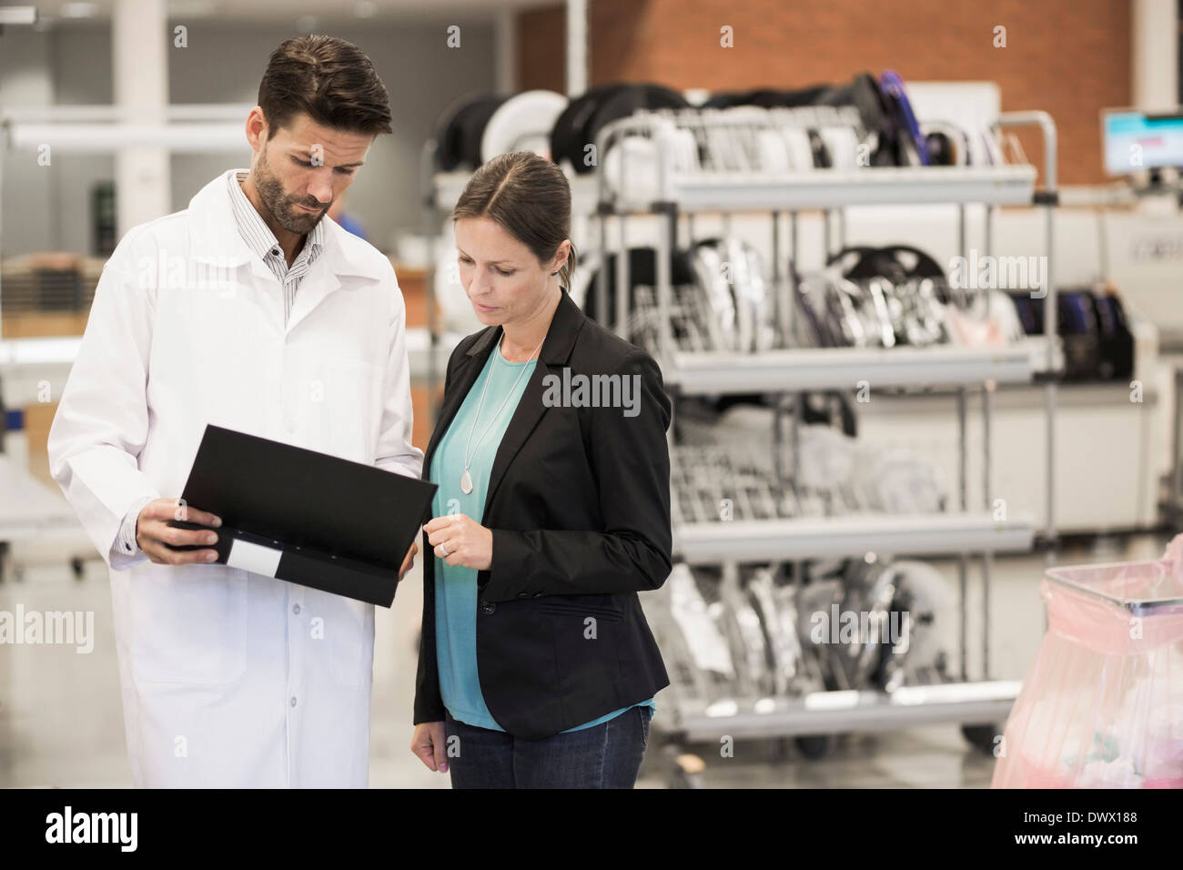 Geschäftsfrau und Ingenieur Datei im Werksgelände Stockfoto