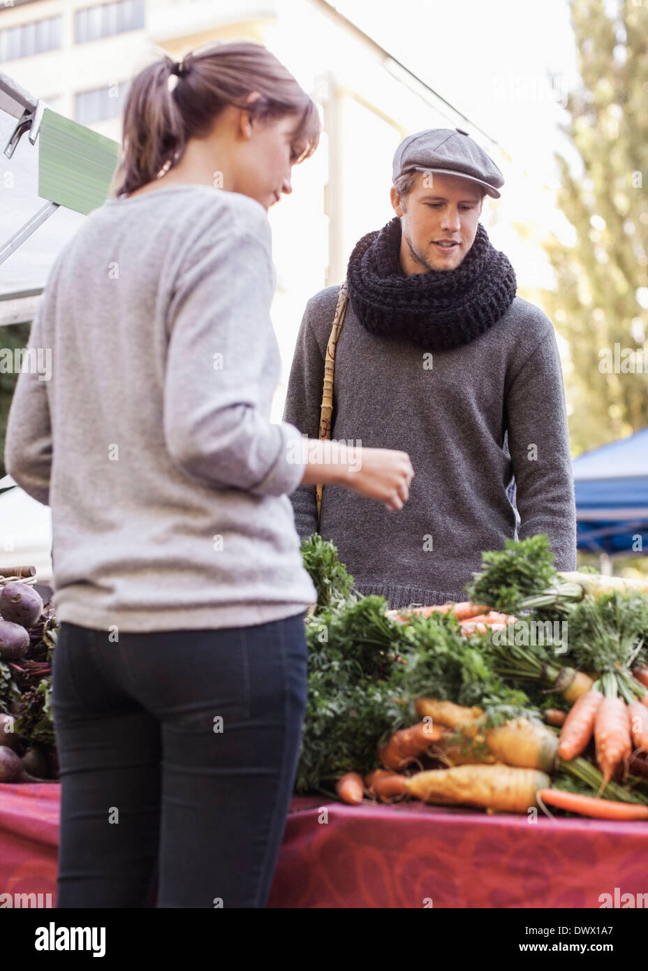 Junger Mann kaufen Gemüse am Marktstand Stockfoto