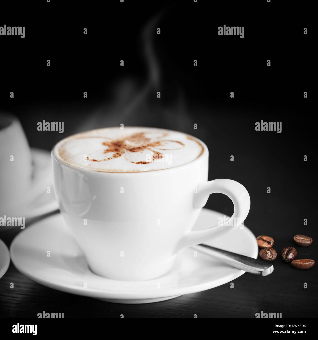 Weiße Tasse heißen Cappuccino auf schwarzem Hintergrund Stockfoto