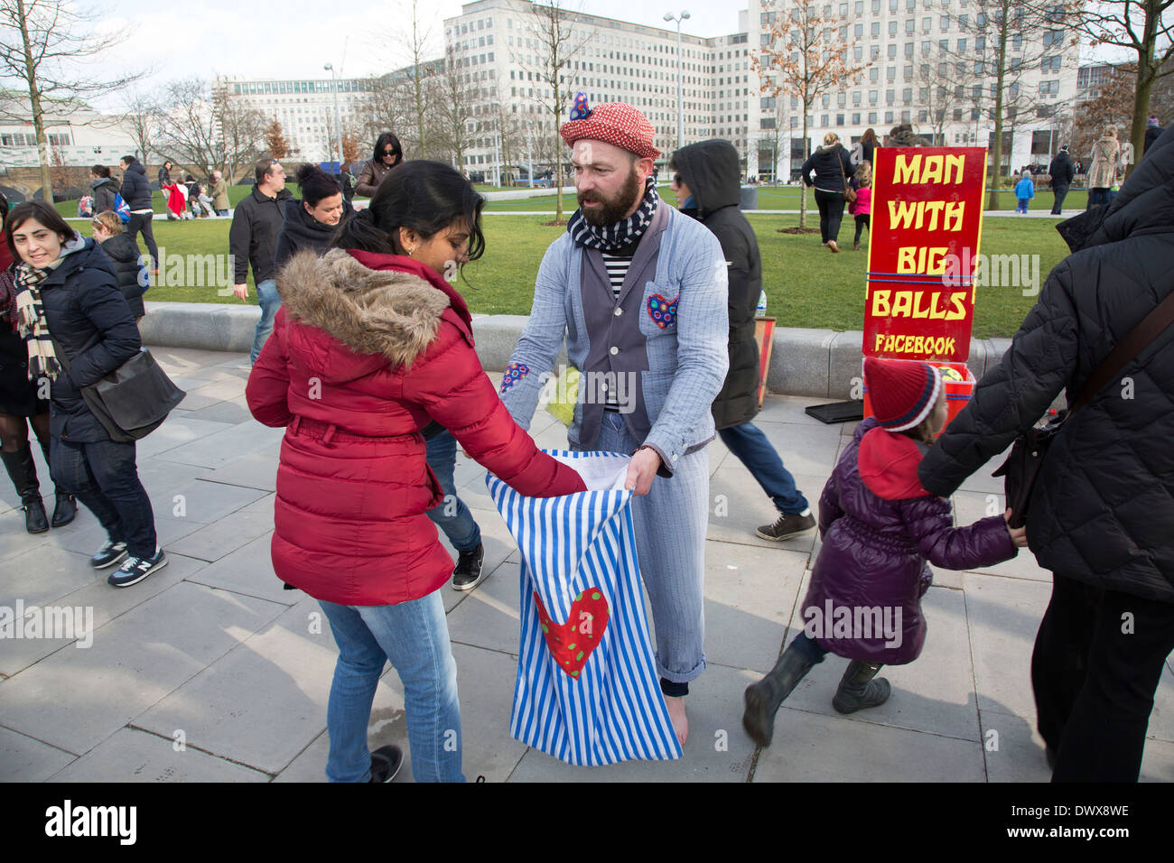 Mann mit großen Bällen Straße Entertainer sammelt Geld von seinem Publikum nach der Durchführung auf der South Bank, London, UK. Stockfoto