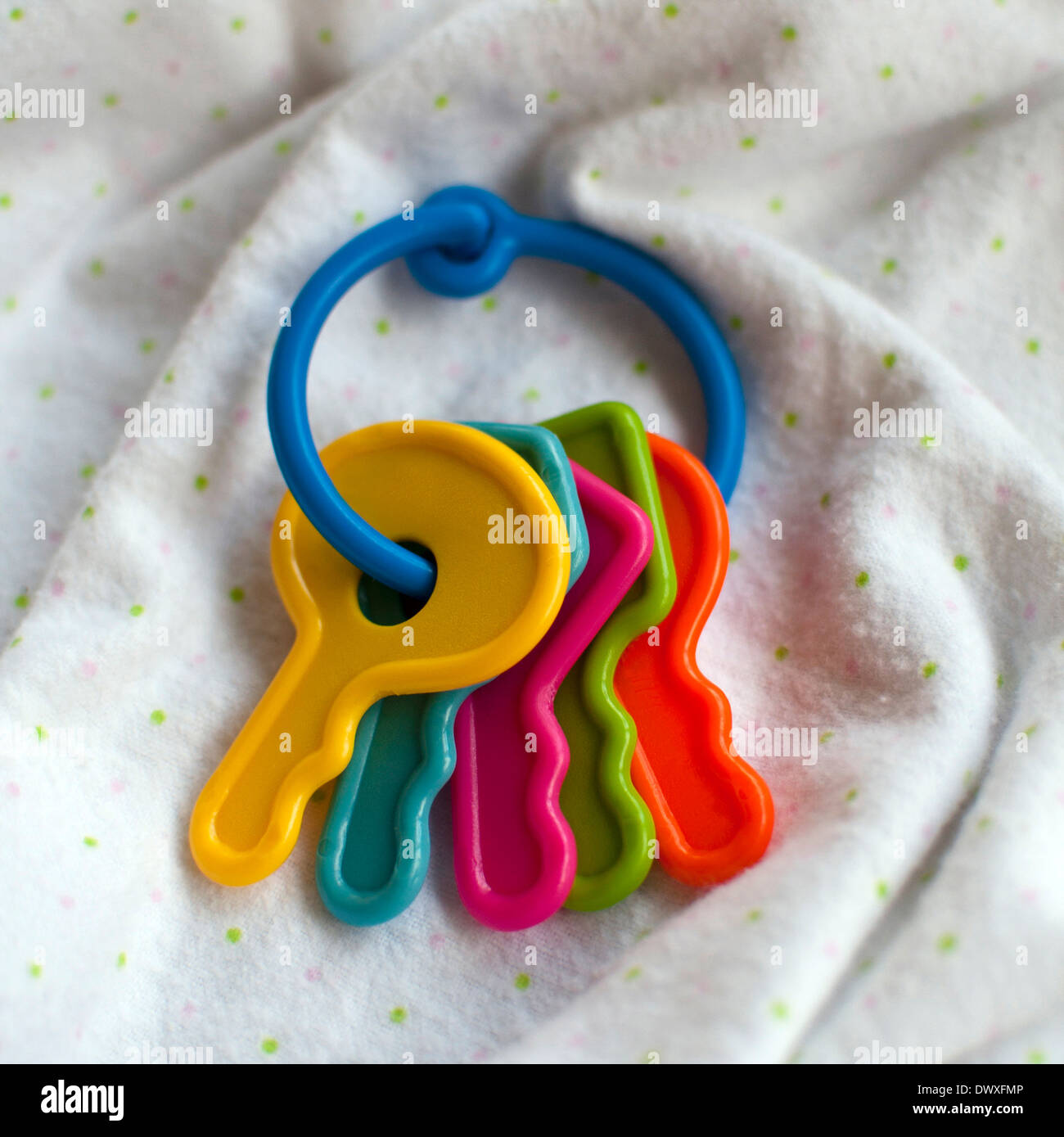 Baby-Spielzeug-Tasten auf einer weichen weißen Decke Stockfoto
