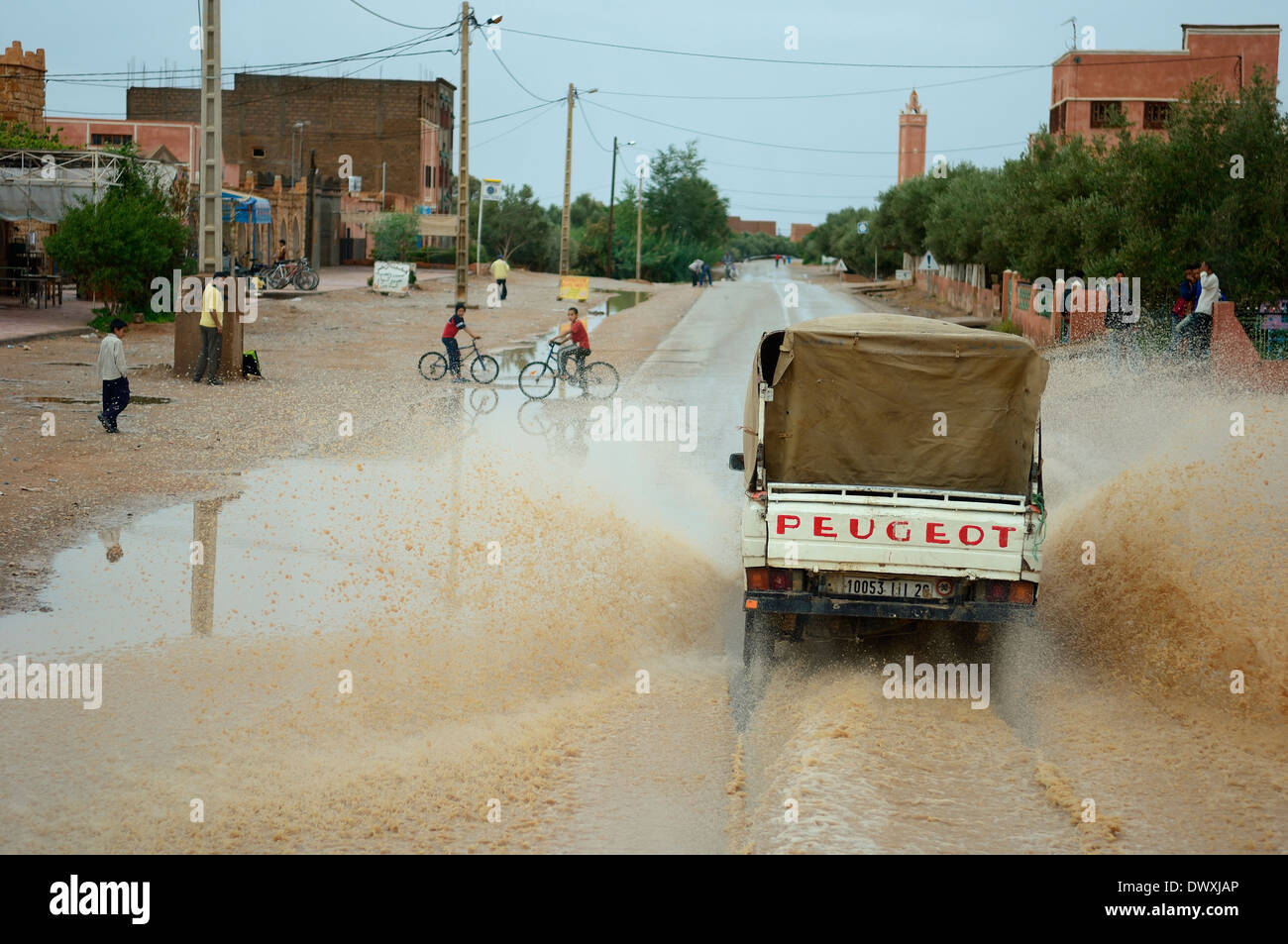 Kleine LKW-fahren durch einen großen Regen Dusche Pfütze. Marokko Stockfoto