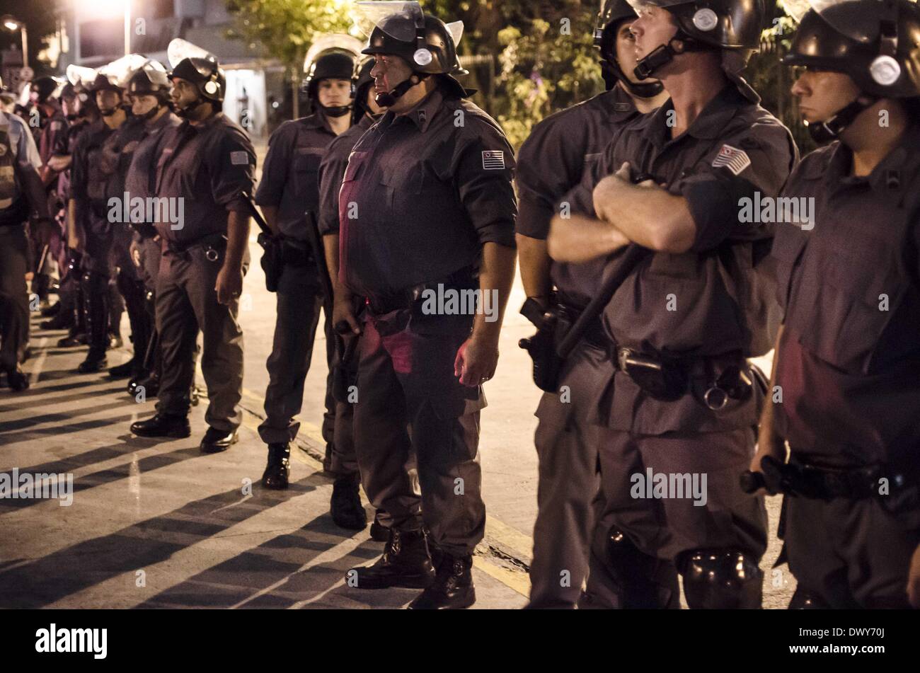 Sao Paulo, Brasilien. 13. März 2014. Unbadged Polizisten folgen die Demonstranten entlang der Avenue im westlichen Teil von Sao Paulo, Brasil, an diesem Donnerstag (13), während der dritte Demonstration gegen die WM. Einige 3,000 Demonstranten teilgenommen und rund um die bestimmte Anzahl von Polizisten folgten ihnen. Rund 45 Polizisten trugen Abzeichen - nicht, was nach brasilianischem Recht verboten ist. Der nächsten Protest findet im 27. März statt, und die Organisatoren sagen, dass es Trog des Landes zu verbreiten. WM kann beginnen im Juni 12. Credit: Gustavo Basso/NurPhoto/ZUMAPRESS.com/Alamy Live News Stockfoto