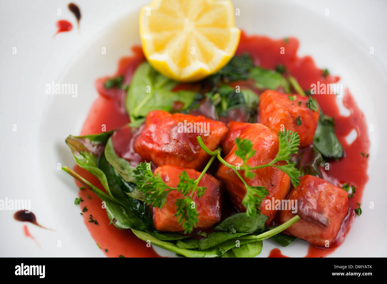 Wildlachs gefangen in einer Verringerung der Sauce mit grünen Stockfoto