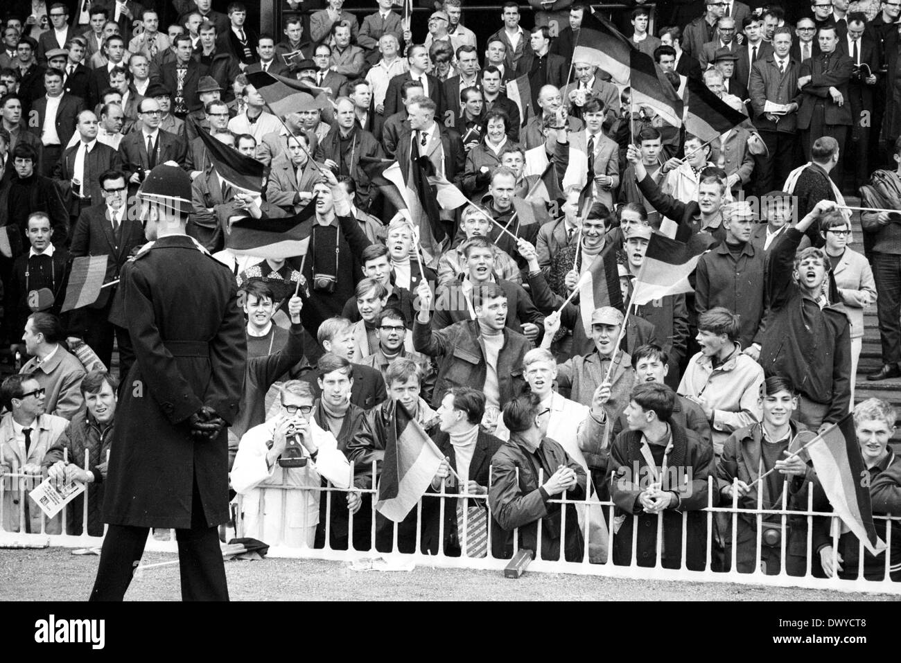 30.07.1966. Wembley Stadium, London England. 1966 World Cup final England gegen Deutschland (4: 2) nach Verlängerung. Deutsche Fans in voller Stimme genau beobachtet von einem englischen Polizisten Stockfoto