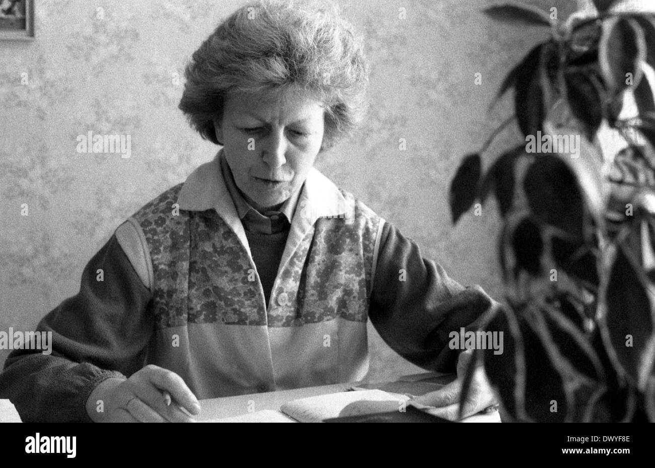 Berlin, DDR, Frau sitzt an einem Schreibtisch, blättert in einem Tagebuch Stockfoto