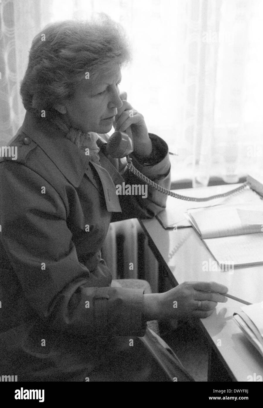 Berlin, DDR, Frau sitzt an einem Schreibtisch und einem Telefon Stockfoto