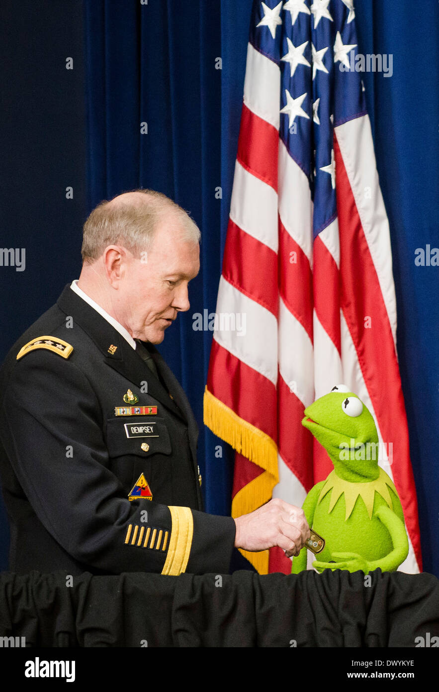 US Joint Chiefs Chairman General Martin Dempsey präsentiert Kermit den Frosch mit einer Service-Münze, wie sie Soldaten und deren Angehörige auf eine Filmvorführung des neuen Muppets Film, "Muppets Most Wanted", im Weißen Haus 12. März 2014 in Washington, DC begrüßen. Stockfoto