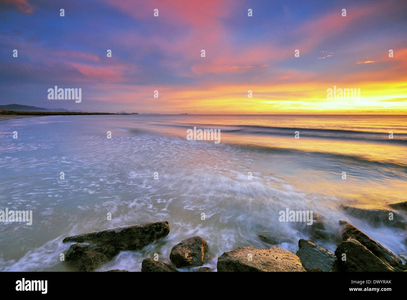 Sonnenuntergang und Wellen am Strand in Kota Kinabalu, Sabah, Borneo, Malaysia. Stockfoto