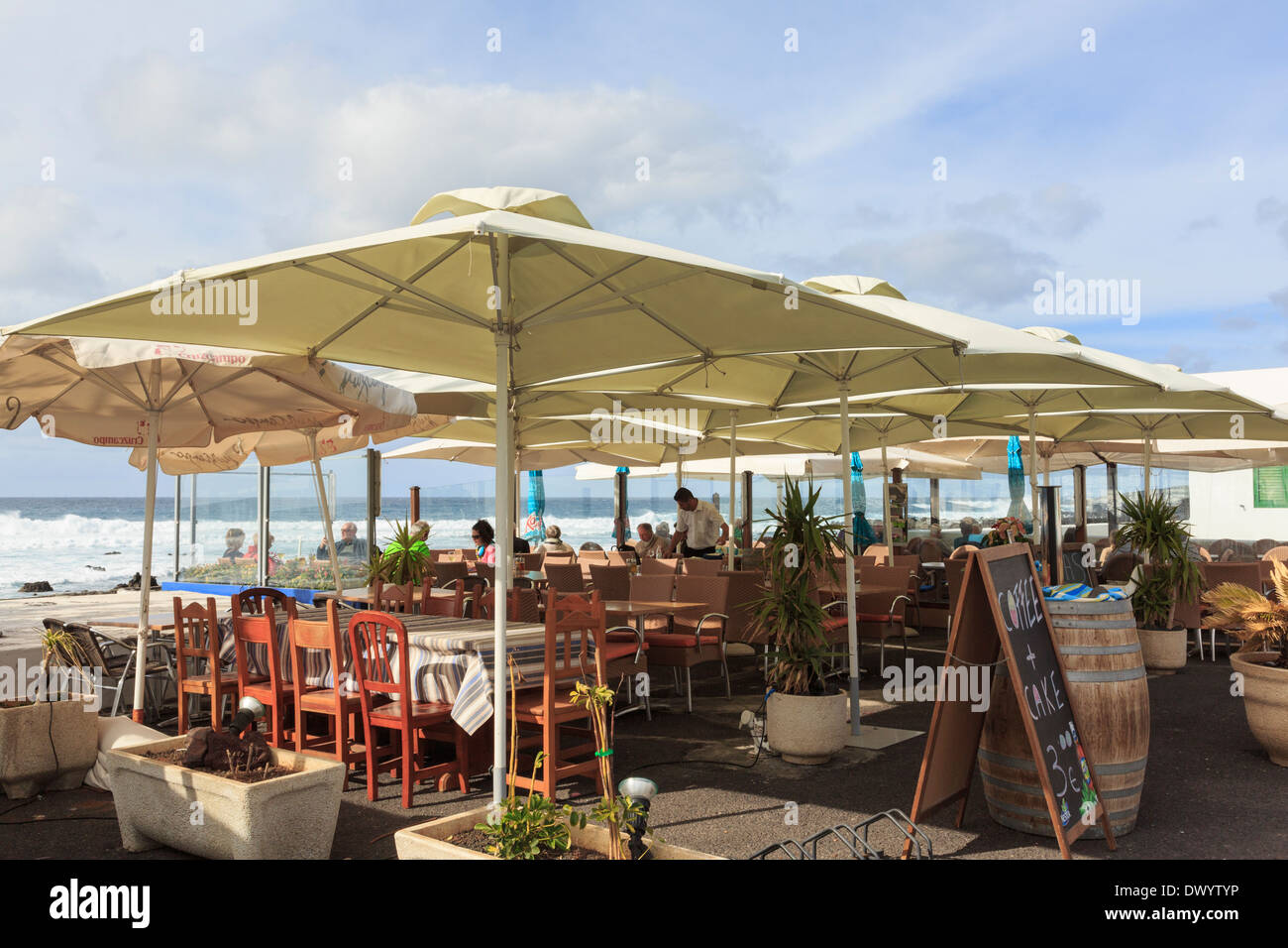 Menschen Essen unter Sonnenschirmen im Strandrestaurant in El Golfo, Lanzarote, Kanarische Inseln, Spanien, Europa. Stockfoto