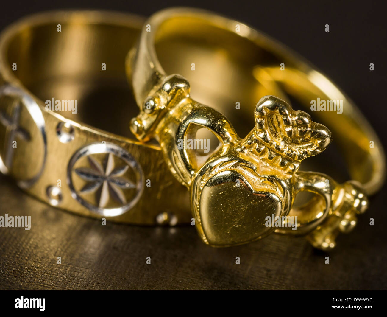 Zwei gold Trauringe, einschließlich einen Claddagh Ring mit einer Krone. Stockfoto