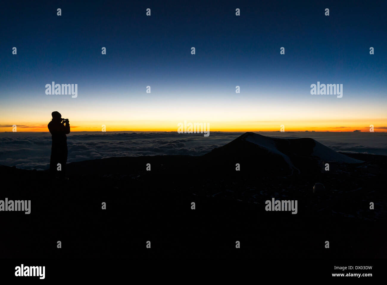Silhouette von Touristen nehmen Foto auf Mauna Kea Gipfel kurz nach Sonnenuntergang. Big Island von Hawaii. Stockfoto
