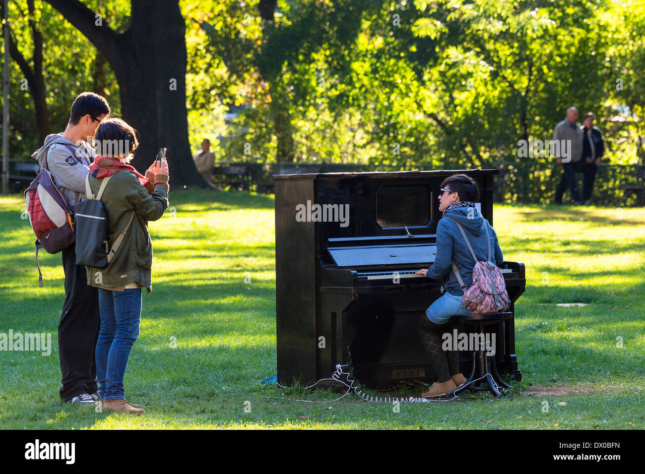Junge Menschen in einem Park im Kampa Klavierspiel Stockfoto
