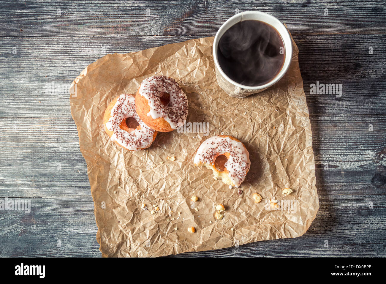 Heißer Kaffee und Donuts in das Papier gegeben Stockfoto