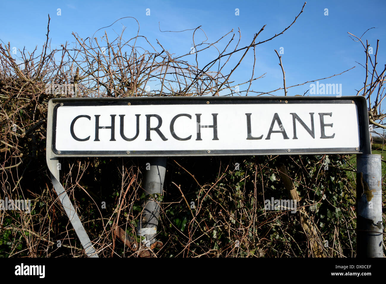 Verkehrszeichen für Church Lane, einem gemeinsamen Straßennamen, gegen eine ländliche Hecke Stockfoto