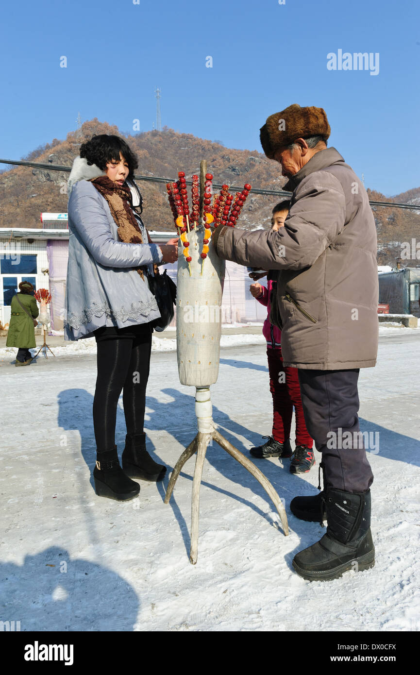 Straßenhändler verkaufen "Weißdorn" an einen Client in der Winterzeit. Provinz Jilin, China. Stockfoto