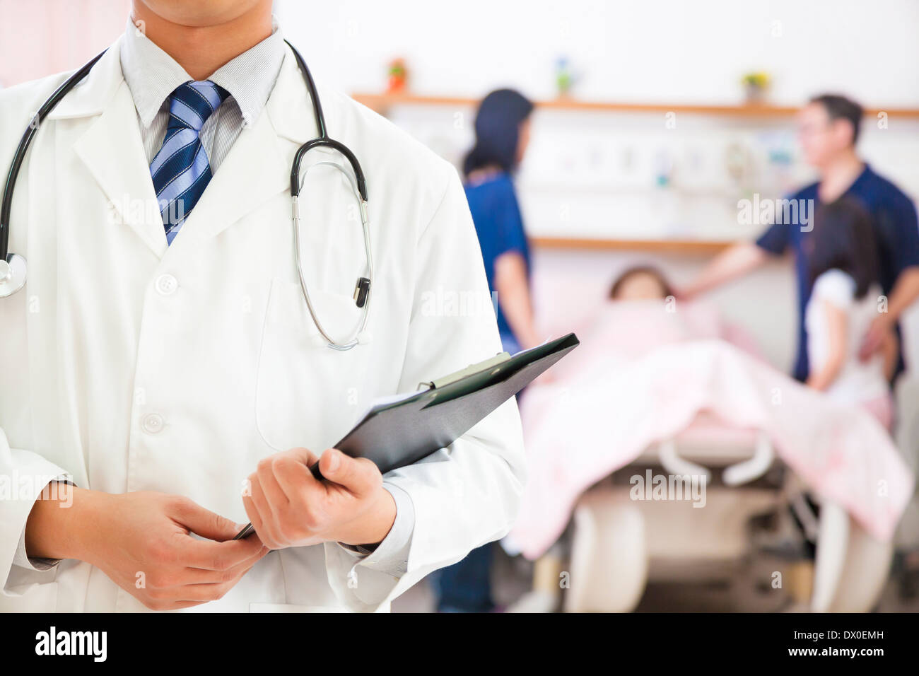 Arzt hält eine Anamnese mit gefälschten Patient und Familie im Krankenhaus Stockfoto