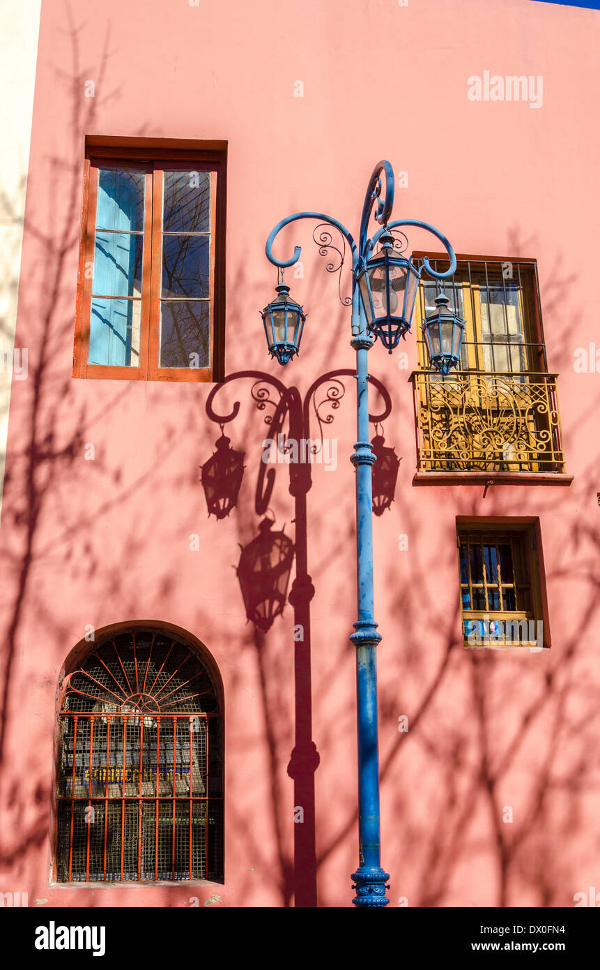 Blaue Straßenlaterne in La Boca-Viertel von Buenos Aires neben einem rosafarbenen Gebäude Stockfoto