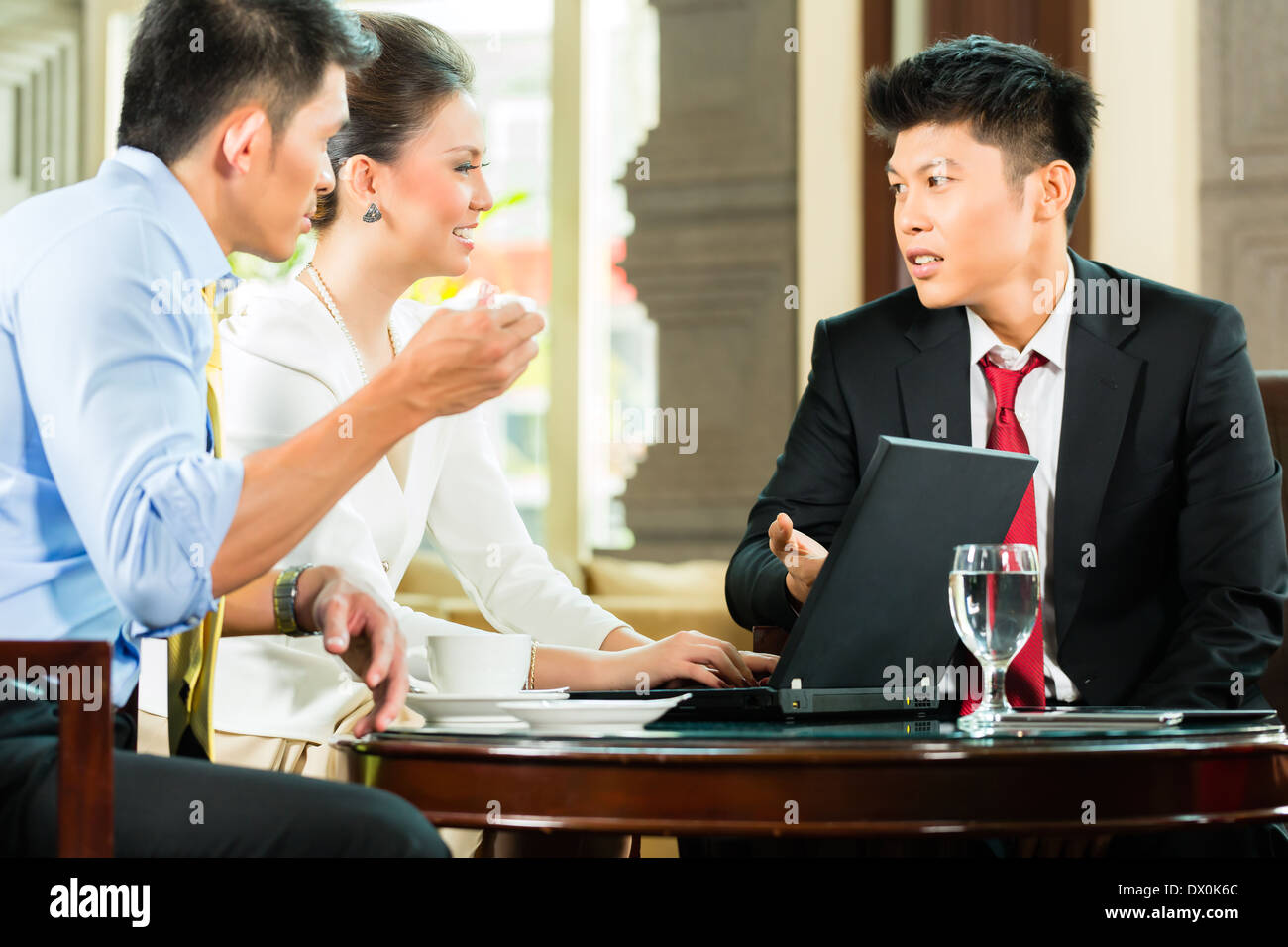 Drei asiatische chinesische Büro Menschen oder Geschäftsleute und Geschäftsfrau, die mit einem Business-Meeting in einer Hotel-lobby Stockfoto