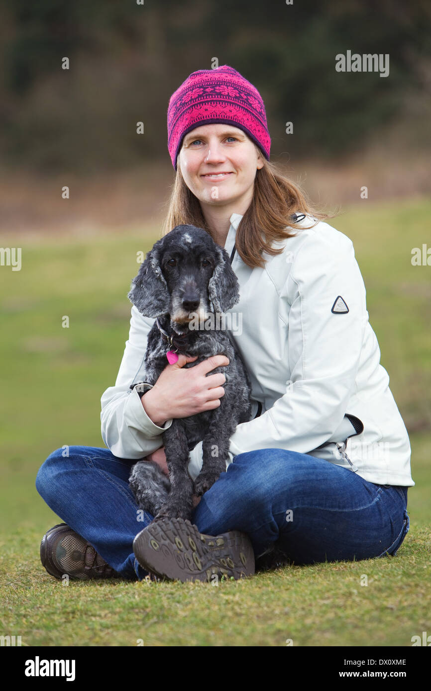 Ein Alter Cocker Spaniel Hund draußen auf dem Rasen auf dem Lande mit seinem Besitzer Stockfoto