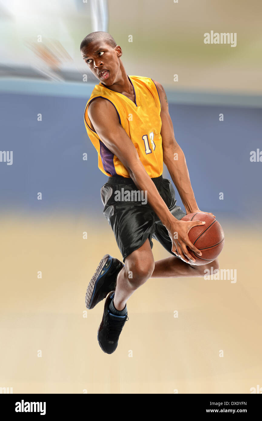 Afrikanische amerikanische Basketballspieler dunking Kugel über der Hintergrund jedoch unscharf Stockfoto
