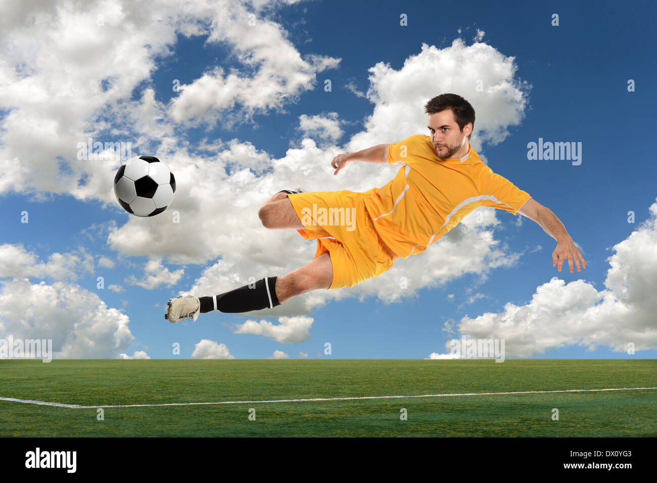 Fußball-Spieler treten Ball draußen im hellen Tag Stockfoto
