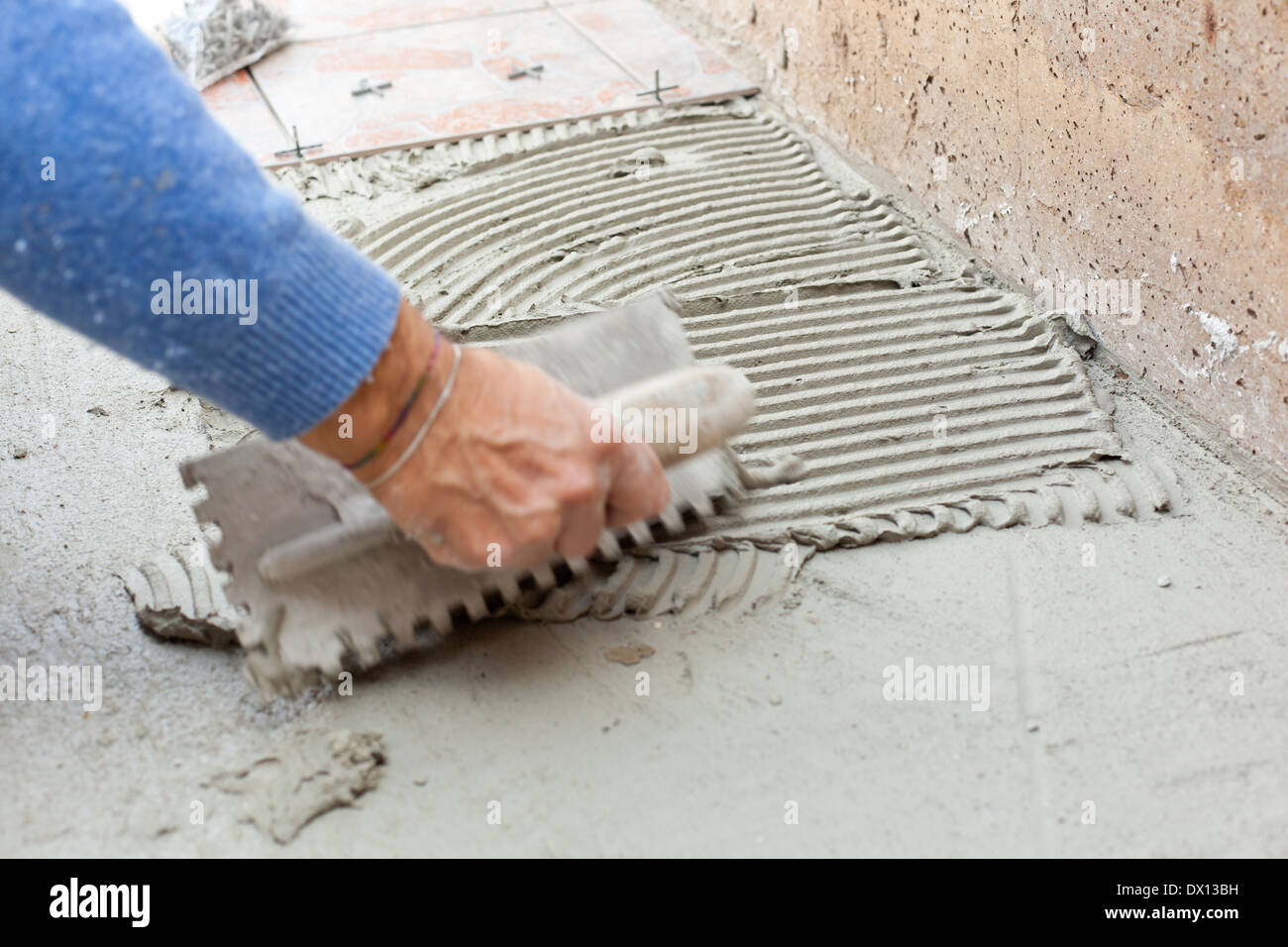 Fliesenleger arbeitet mit Bodenbelag im Hinterhof. Stockfoto