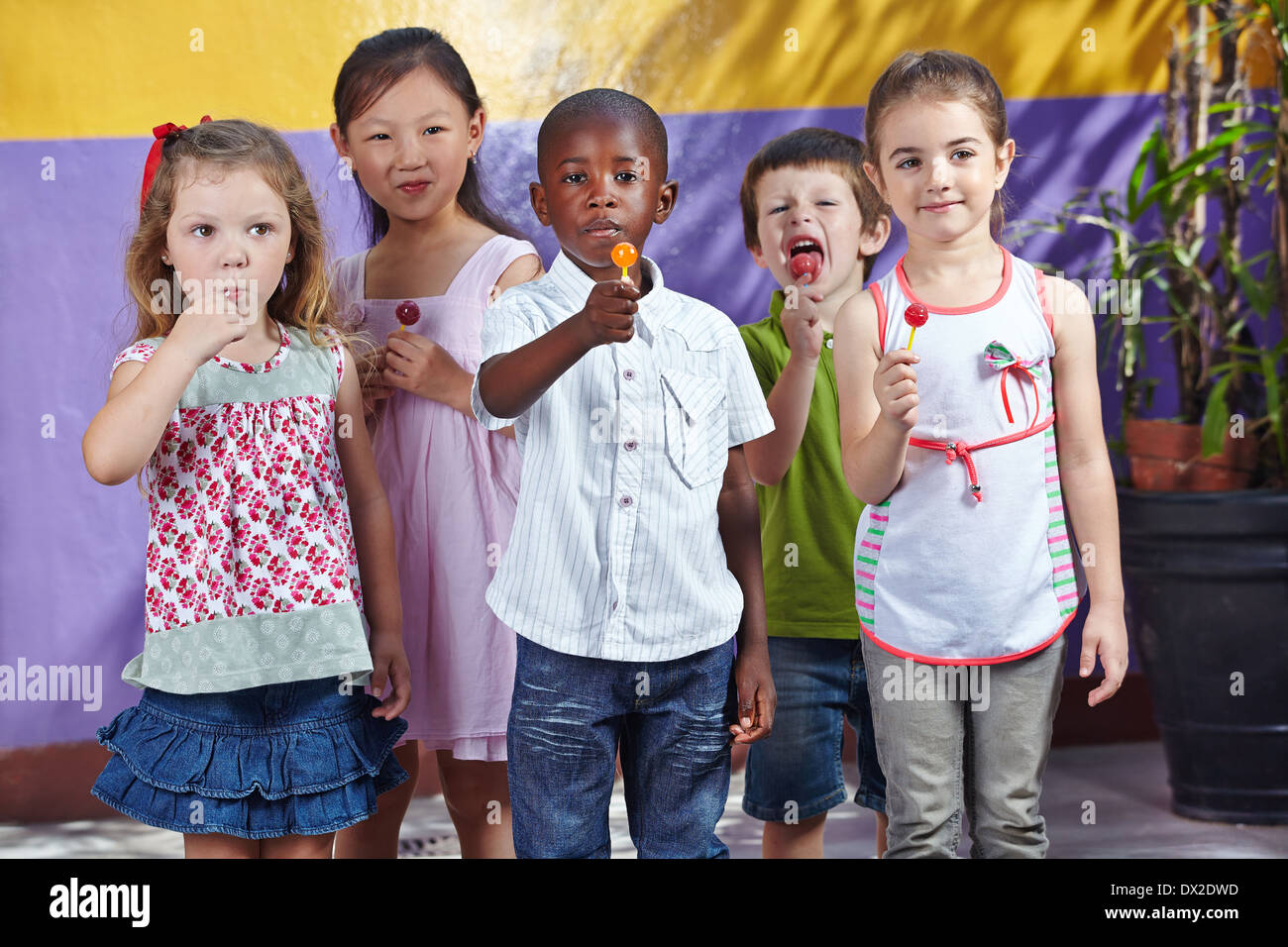 Interracial Gruppe von Kindern in einem Kindergarten Essen Saugnäpfe Stockfoto