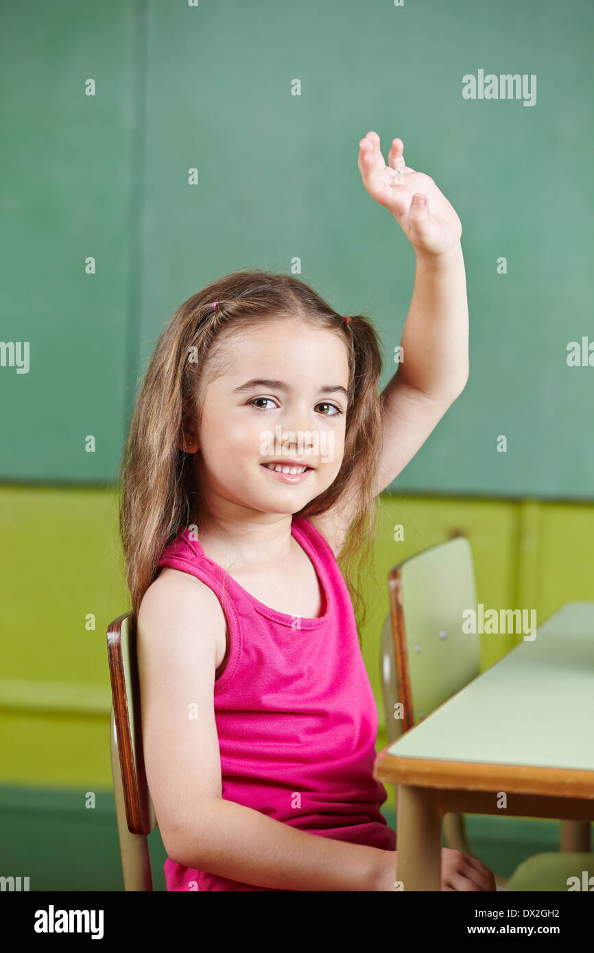 Lächelndes Mädchen hob ihre Hand in der Grundschule Klasse Stockfoto