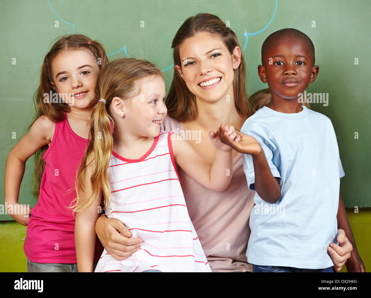 Glückliche Frau mit drei anderen Kindern in einem kindergarten Stockfoto
